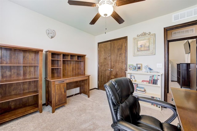 office space with visible vents, light colored carpet, and ceiling fan