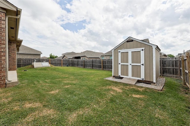 view of yard with an outbuilding, a storage unit, and a fenced backyard