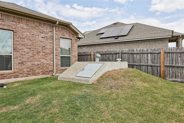 view of storm shelter with a lawn and a fenced backyard