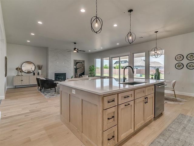 kitchen with recessed lighting, light wood finished floors, a ceiling fan, a sink, and a fireplace