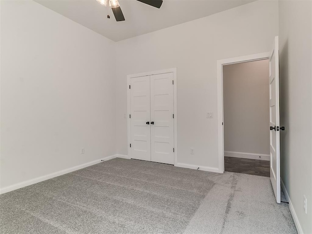unfurnished bedroom with baseboards, a ceiling fan, carpet flooring, and a closet