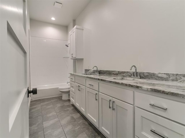 bathroom featuring marble finish floor, a sink, double vanity, and toilet