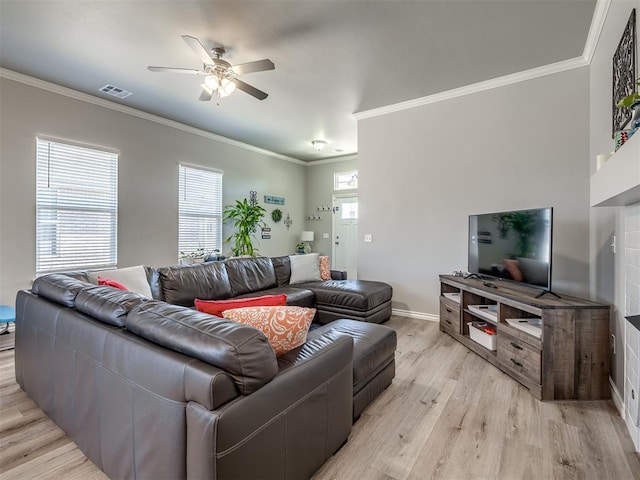 living area with ornamental molding, a ceiling fan, visible vents, and light wood-type flooring