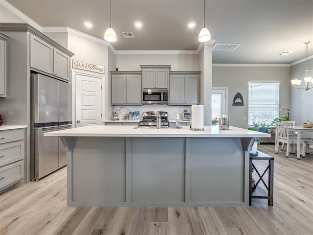 kitchen featuring a sink, stainless steel appliances, gray cabinetry, and visible vents