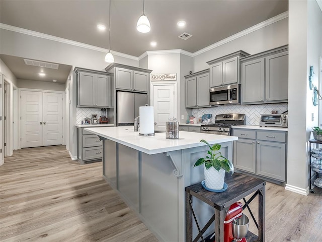 kitchen with light wood-type flooring, visible vents, gray cabinets, stainless steel appliances, and light countertops