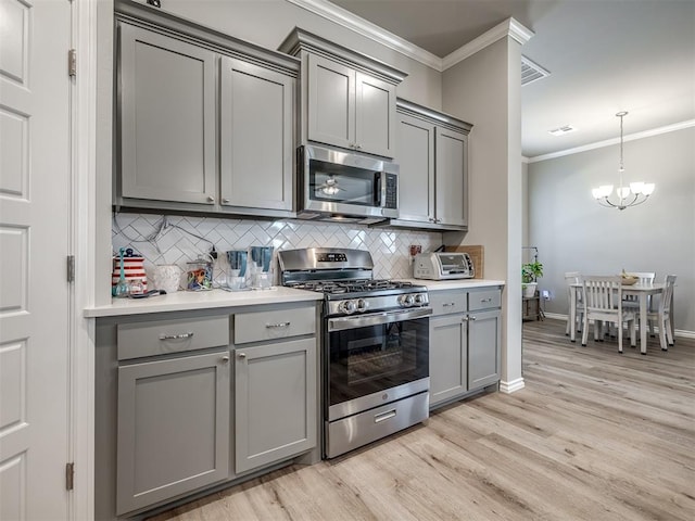 kitchen with stainless steel appliances, gray cabinets, and crown molding