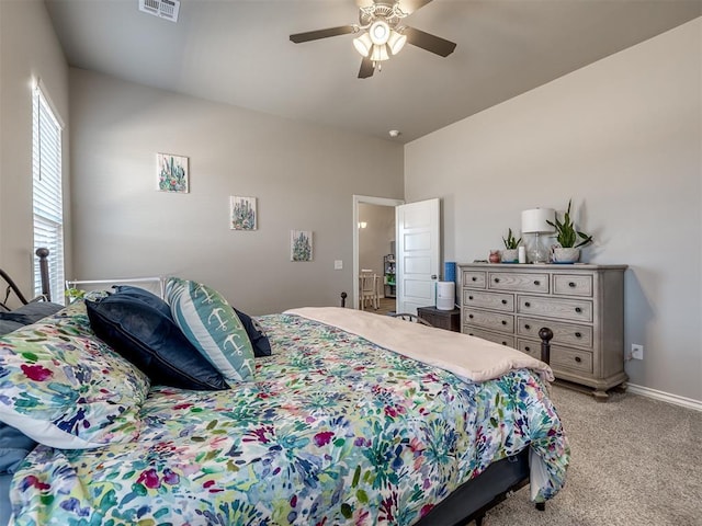 bedroom with visible vents, baseboards, light colored carpet, and a ceiling fan