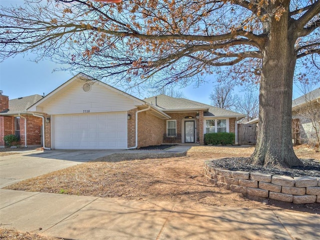 ranch-style home with brick siding, an attached garage, concrete driveway, and a shingled roof