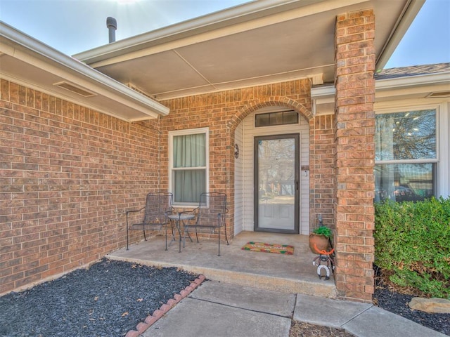 entrance to property with brick siding and covered porch