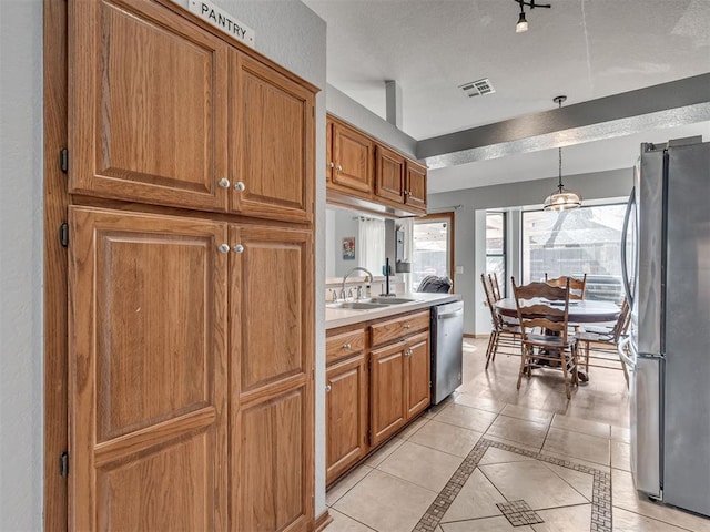 kitchen with a sink, visible vents, appliances with stainless steel finishes, and brown cabinetry