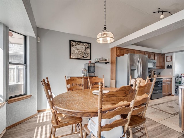 dining area featuring baseboards and light wood-style flooring