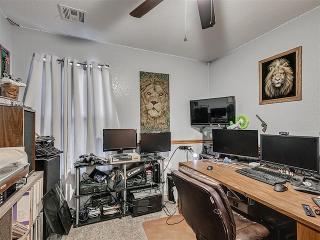 office space featuring visible vents, a ceiling fan, and carpet floors