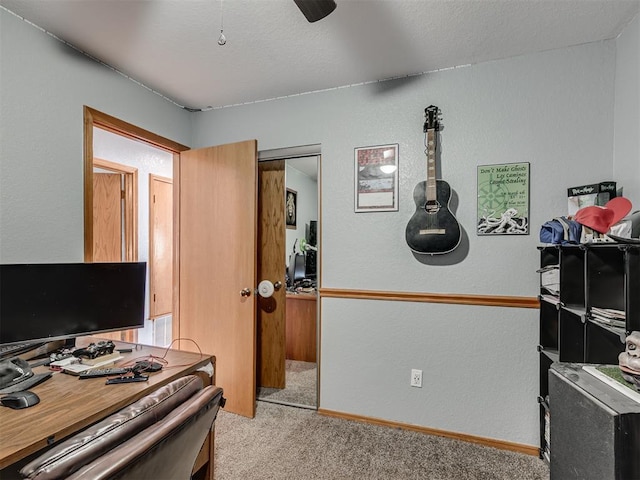 office featuring light carpet, a textured ceiling, baseboards, and a textured wall