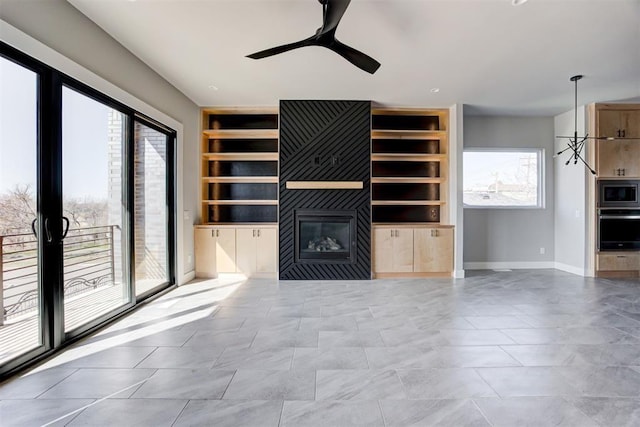 unfurnished living room featuring a fireplace, built in features, a ceiling fan, and baseboards