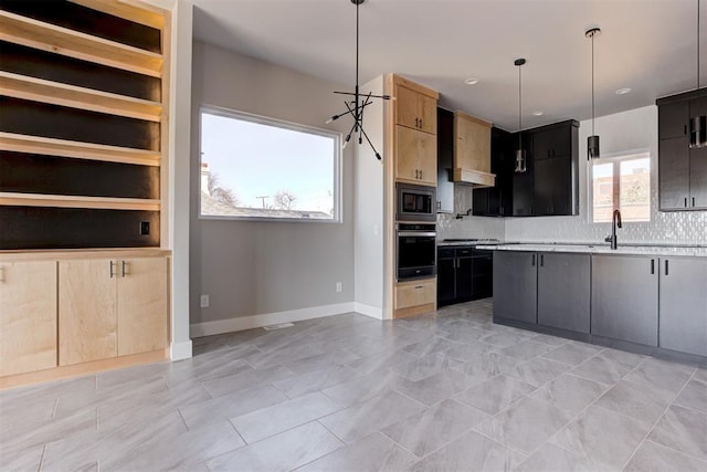 kitchen featuring oven, stainless steel microwave, light countertops, decorative backsplash, and baseboards