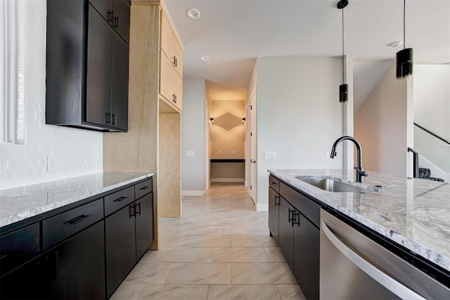 kitchen with a sink, light stone countertops, stainless steel dishwasher, and dark cabinetry