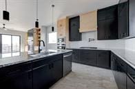 kitchen featuring decorative light fixtures, dishwasher, dark cabinetry, and light countertops