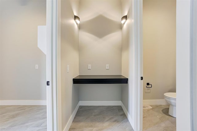 bathroom with toilet and baseboards