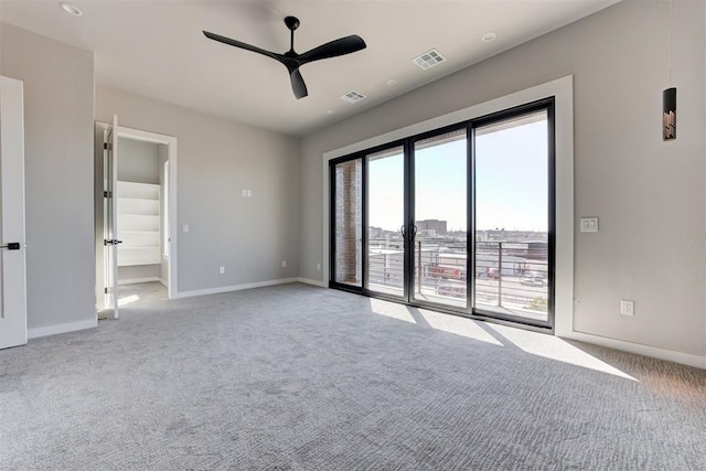 carpeted empty room featuring visible vents, baseboards, and a ceiling fan