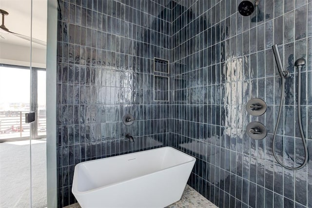 bathroom with a soaking tub, tile walls, and a tile shower