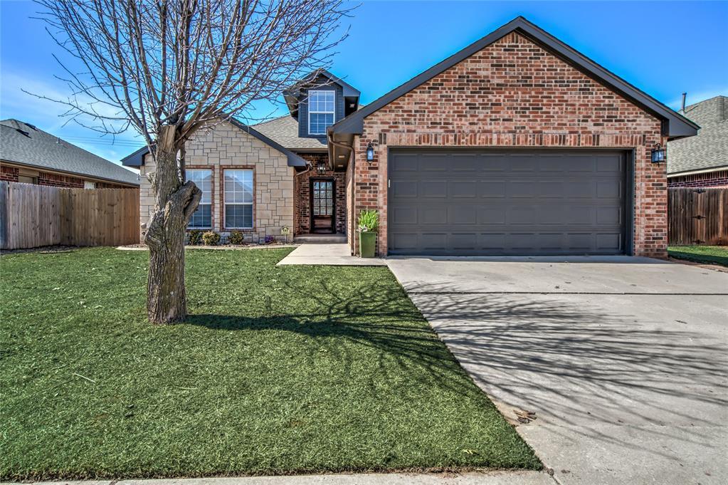 4713 Doe Run Dr, Yukon, OK 73099 - view of front facade with an attached garage, concrete driveway, a front lawn, and fence