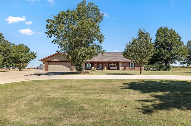 ranch-style home featuring brick siding, an attached garage, a front yard, metal roof, and driveway