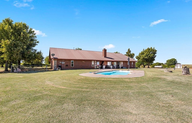 outdoor pool featuring a yard