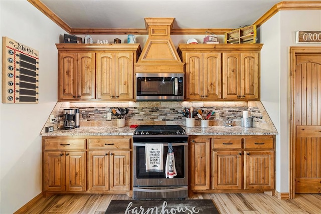 kitchen featuring ornamental molding, light wood-style floors, backsplash, and stainless steel appliances