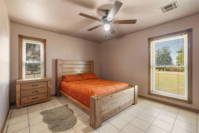 bedroom featuring light tile patterned floors, visible vents, and baseboards