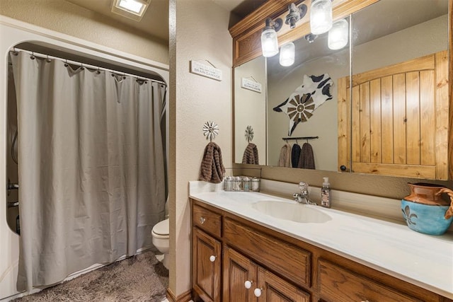 full bath with curtained shower, toilet, vanity, and a textured wall