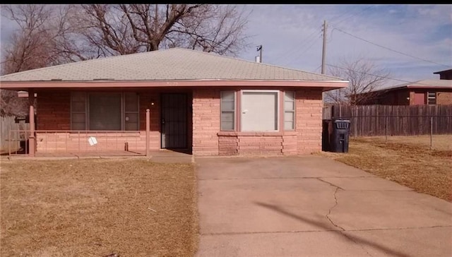 bungalow-style house with brick siding, covered porch, and fence