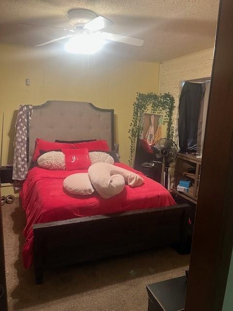 carpeted bedroom with a textured ceiling and a ceiling fan