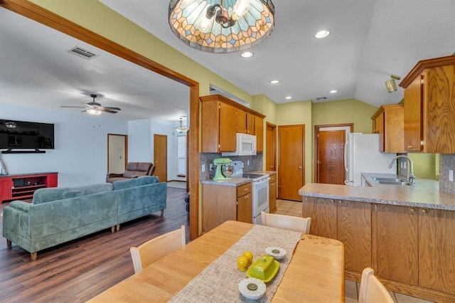 kitchen featuring a sink, visible vents, white appliances, and light countertops