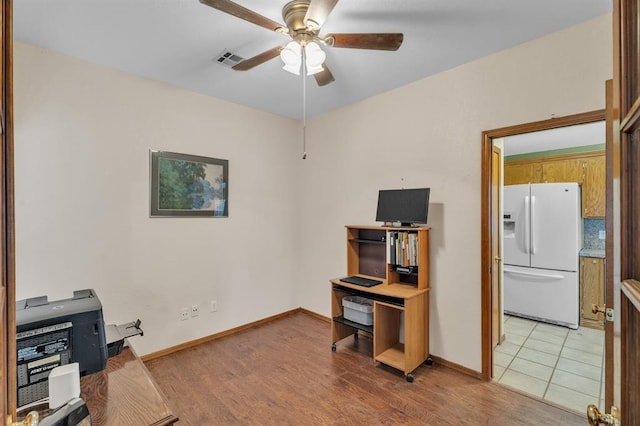 interior space featuring baseboards, light wood-style floors, visible vents, and ceiling fan