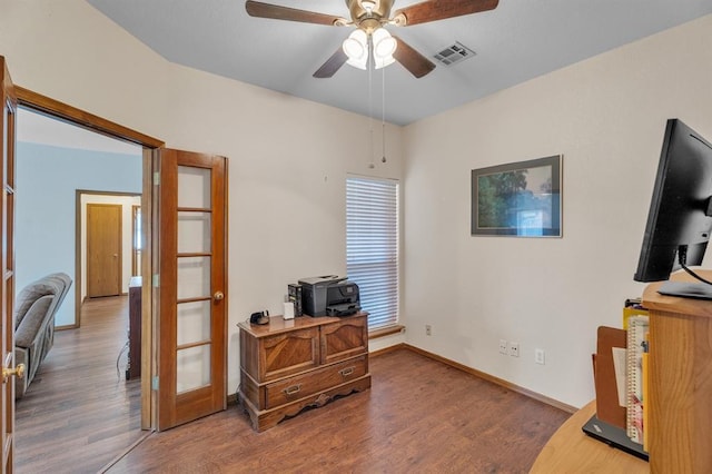 office area with a ceiling fan, wood finished floors, visible vents, and baseboards