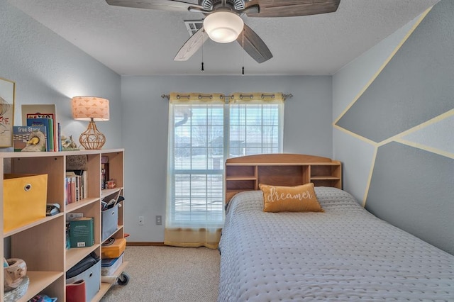 bedroom featuring a textured ceiling, ceiling fan, and carpet floors