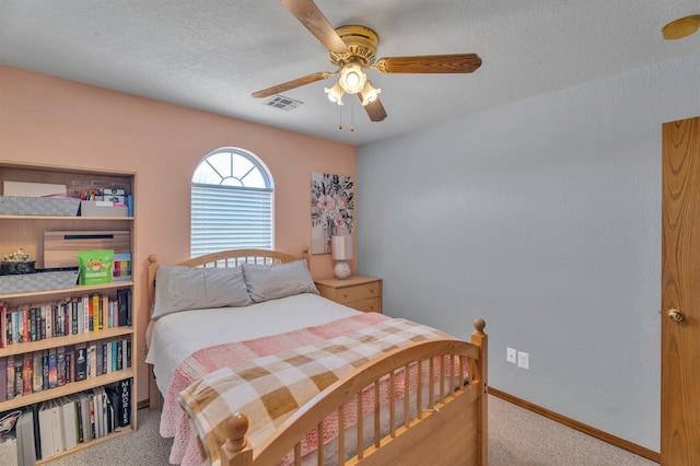 carpeted bedroom with visible vents, ceiling fan, a textured ceiling, and baseboards