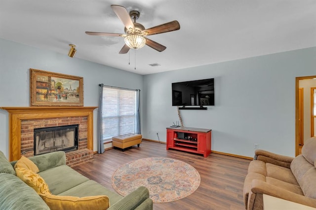 living area featuring a ceiling fan, wood finished floors, visible vents, and baseboards