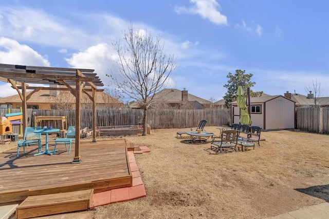 view of yard featuring a shed, a fenced backyard, a deck, an outbuilding, and a pergola