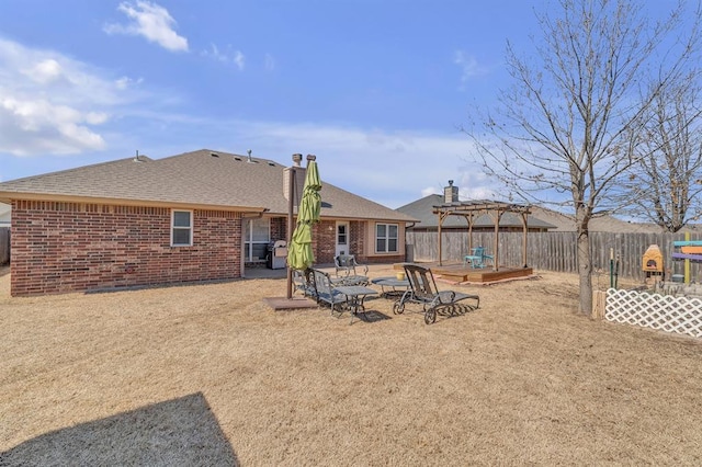 back of house featuring brick siding, a fenced backyard, a pergola, and a shingled roof