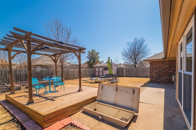 deck featuring an outbuilding, a shed, a pergola, and a fenced backyard