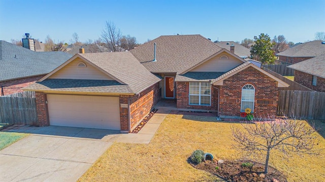 view of front of home featuring a front yard, fence, brick siding, and a shingled roof