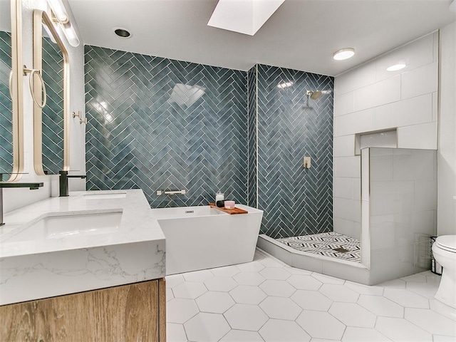 bathroom with tile patterned flooring, vanity, a tile shower, a freestanding tub, and tile walls