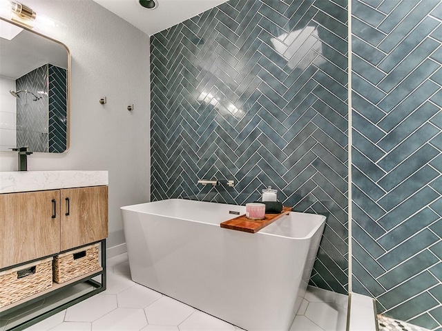 full bathroom with tile patterned floors, a freestanding tub, walk in shower, and vanity