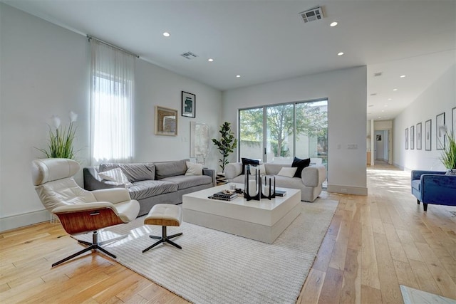 living area with recessed lighting, light wood-style floors, and visible vents