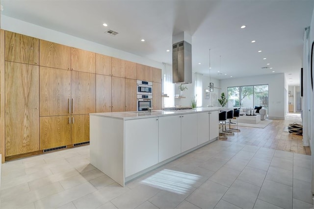 kitchen with open floor plan, appliances with stainless steel finishes, modern cabinets, and visible vents