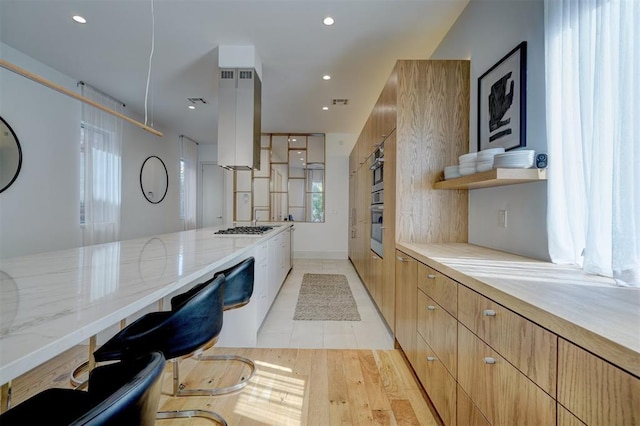 kitchen with light stone counters, modern cabinets, recessed lighting, and gas stovetop