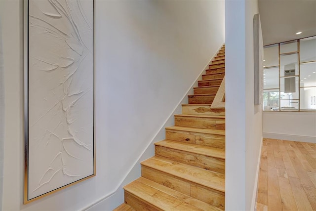 stairway featuring recessed lighting, baseboards, and wood-type flooring