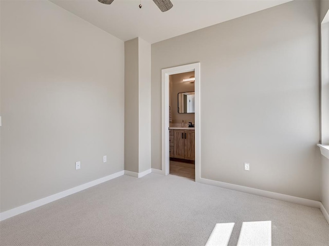 12 S Howard St, Edmond, OK 73003 - unfurnished bedroom with light colored carpet, ensuite bathroom, baseboards, and a sink