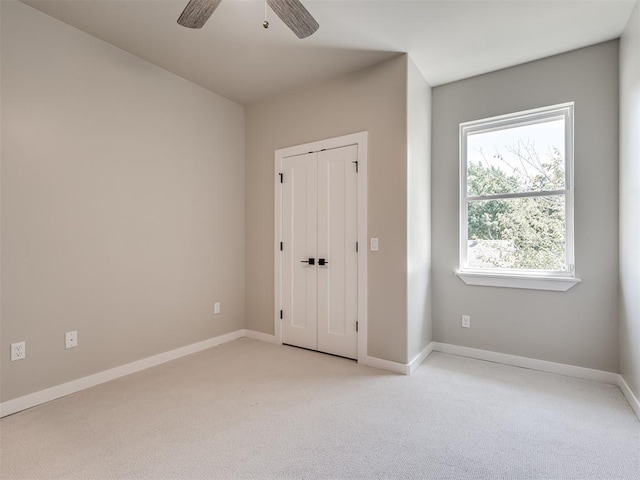 12 S Howard St, Edmond, OK 73003 - unfurnished bedroom with light colored carpet, baseboards, a closet, and ceiling fan